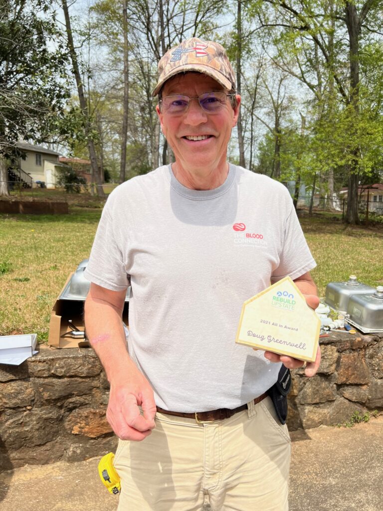 Doug poses with his award on a build site.