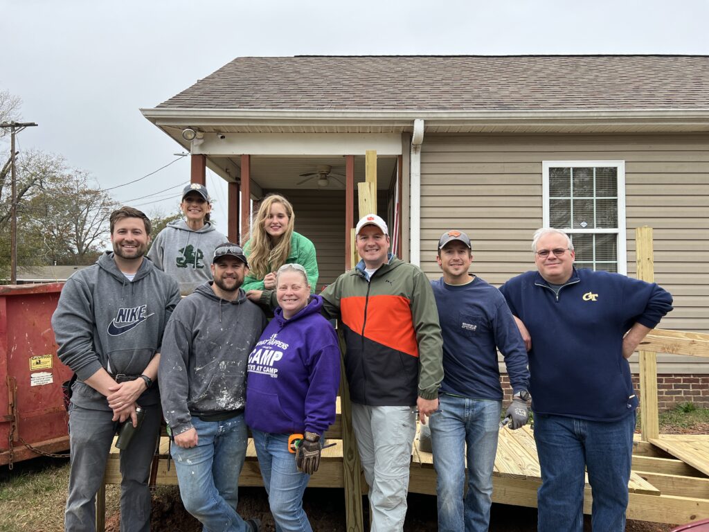 The Rebuild Upstate board of directors poses near an in-progress ramp during a build day.